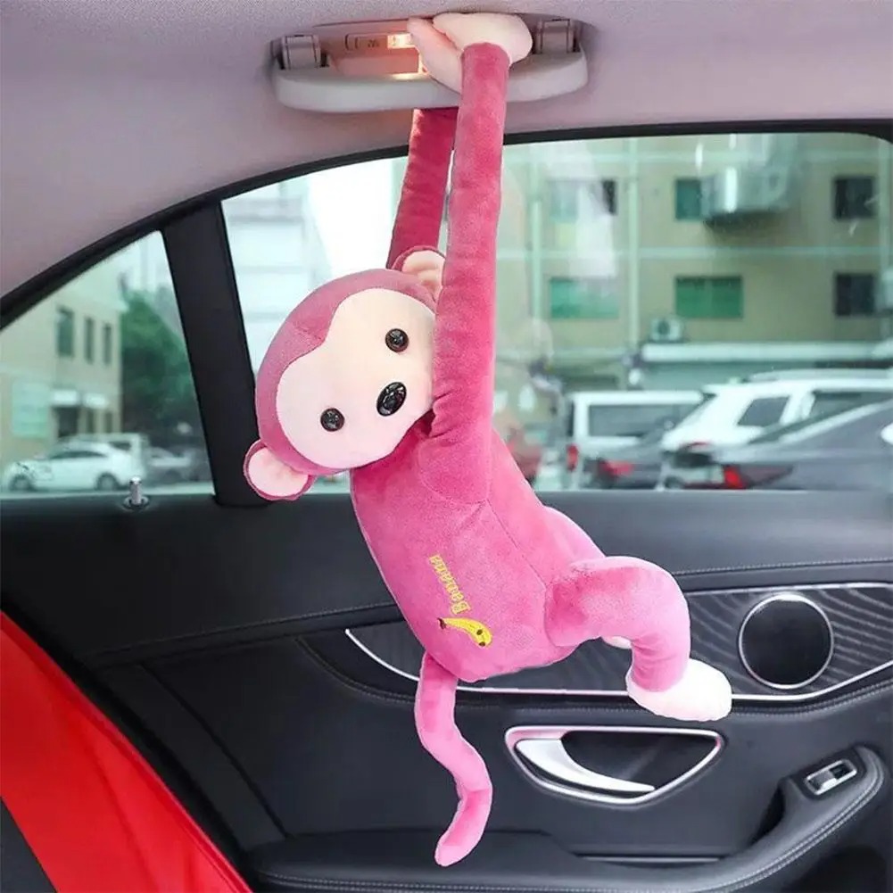 Pink monkey ornament hanging from a car grab handle