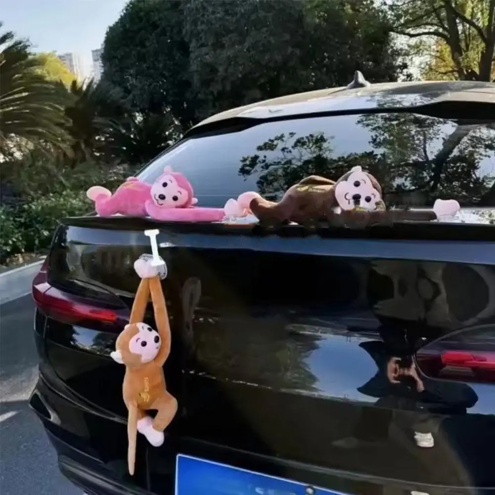 Pink, brown and orange monkey ornaments on a car